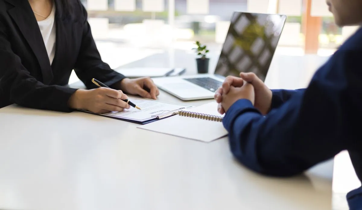 Franke Unternehmensgruppe – Immobilien – Der Manager liest den Lebenslauf und führt das Vorstellungsgespräch mit dem neuen Mitarbeiter. Er verhandelt die Konditionen und unterzeichnet einen Vertrag. Anwalt und Rechtsberater sind ebenfalls beteiligt.